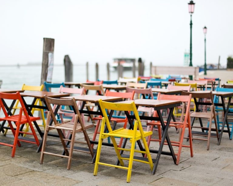 Vibrant tables and chairs set by the waterfront.
