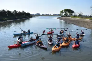 Group of kayakers raising their paddles on a calm tidal creek in Murrells Inlet