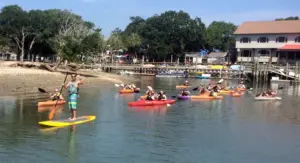 Kayakers and paddleboarders heading out from a marina beach