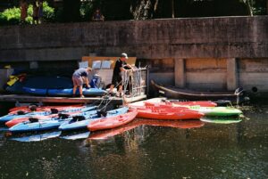 Two paddlers preparing kayaks at a waterside launch