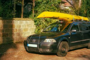 Yellow kayak strapped to the roof rack of a car