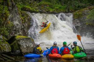 Group of kayakers on a guided tour paddling a calm river
